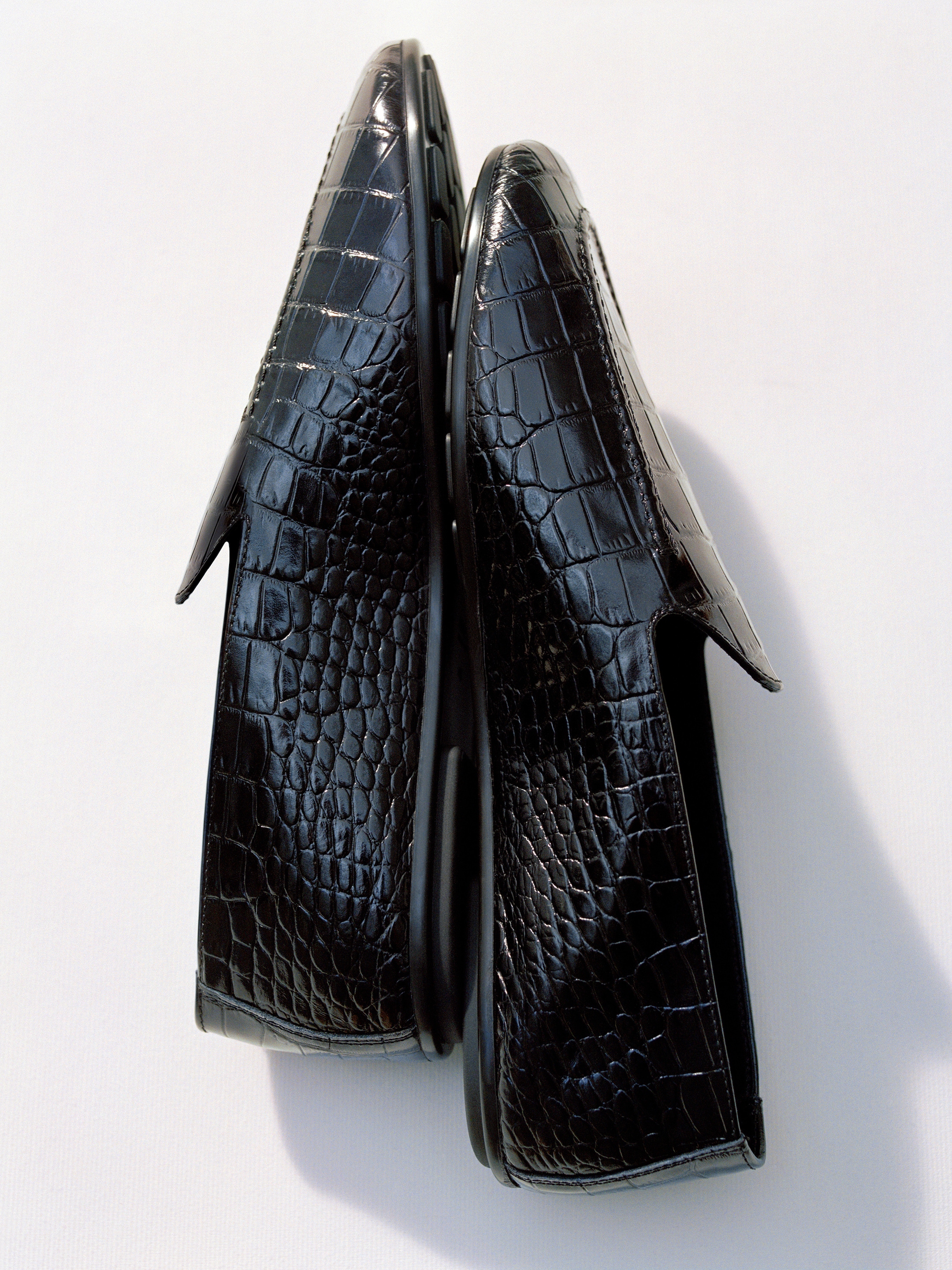 Pair of black leather loafers with a shiny crocodile texture, side by side against a light background.
