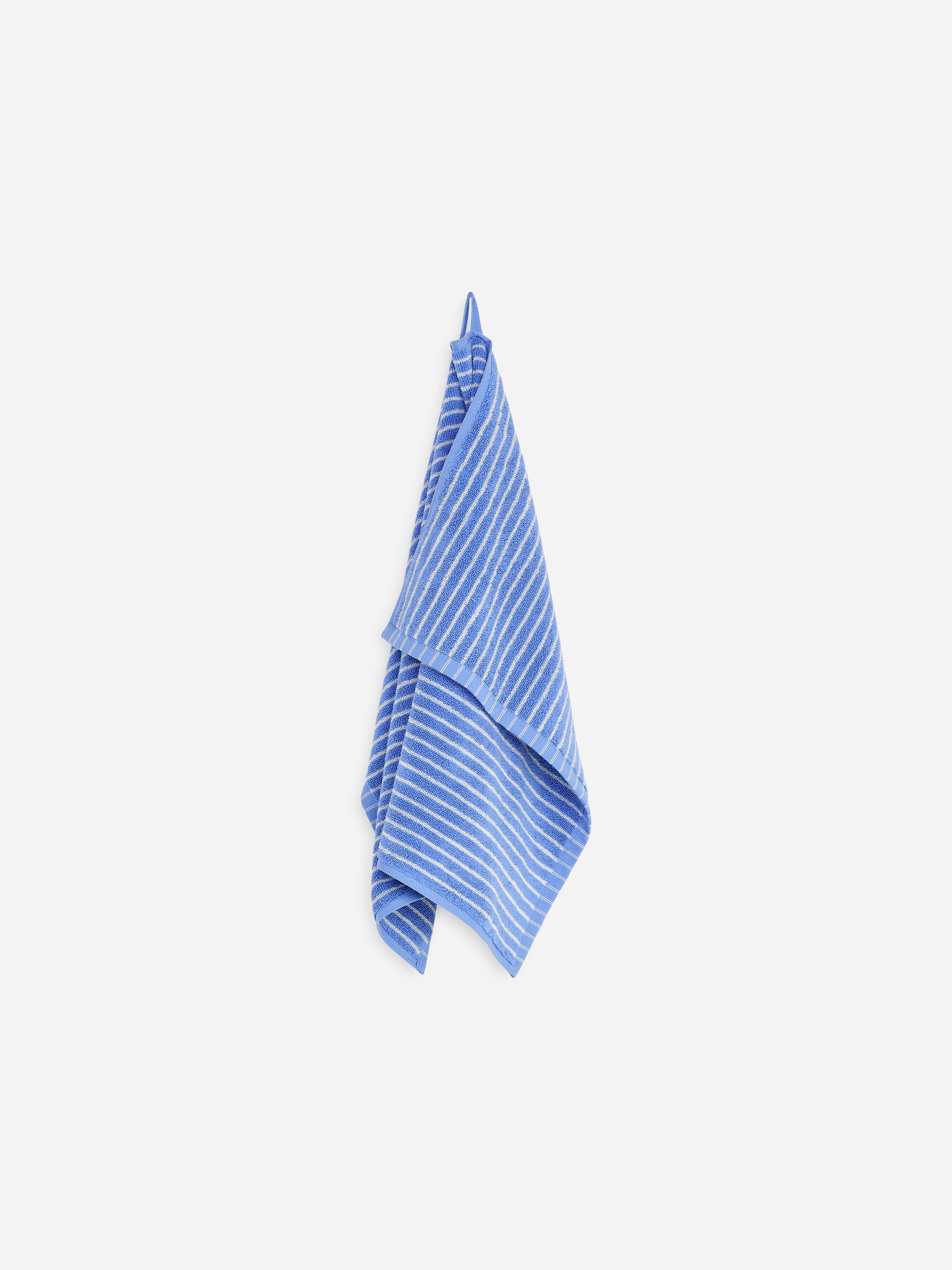 A blue towel with white stripes, hanging on a hook against a plain white background.