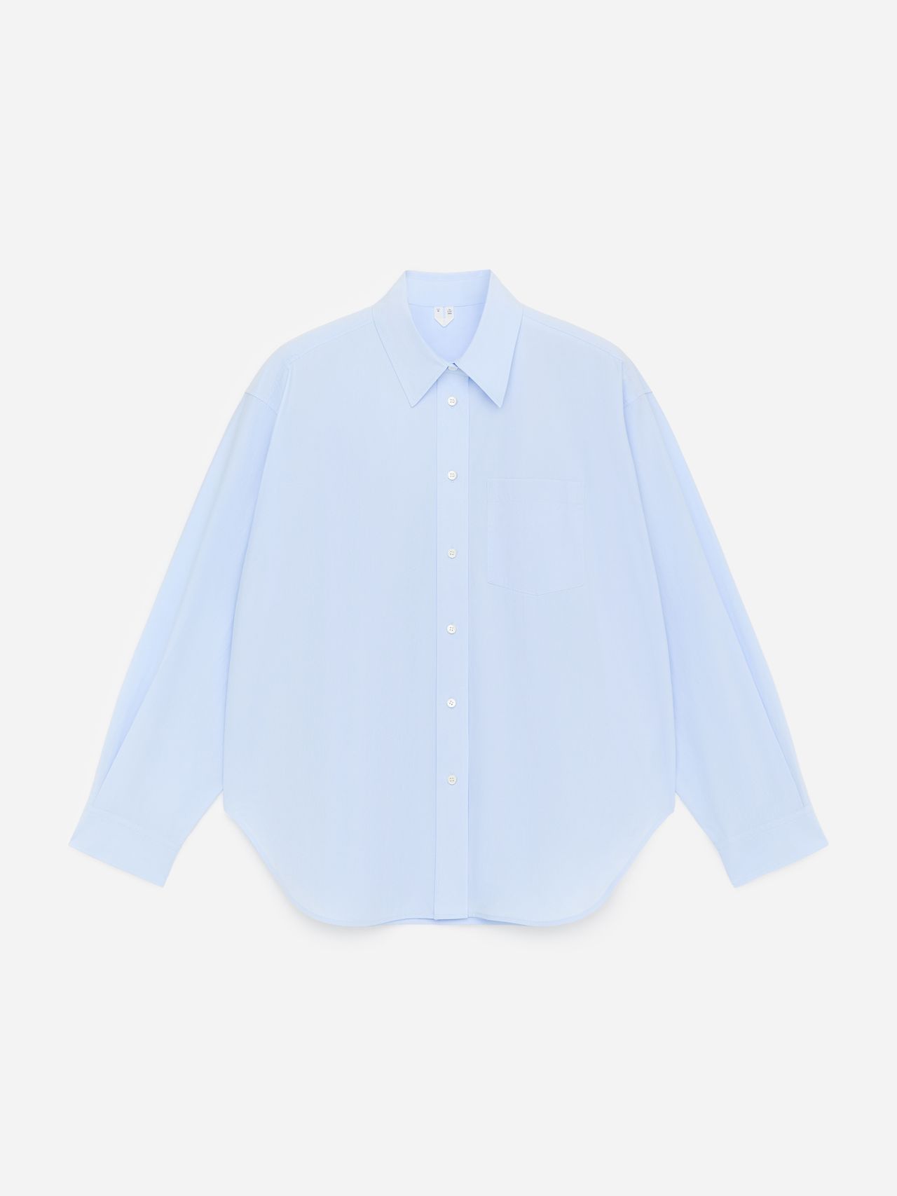 Light blue oversized button-up shirt with a pointed collar and chest pocket, displayed against a plain white background.