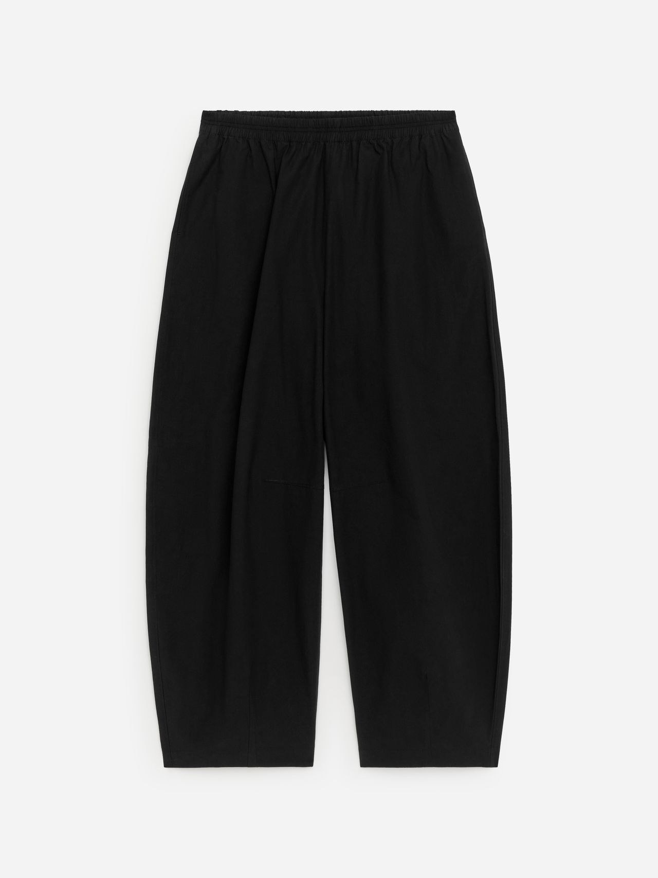 Black, loose-fitting pants with an elastic waistband, laid flat on a white background.