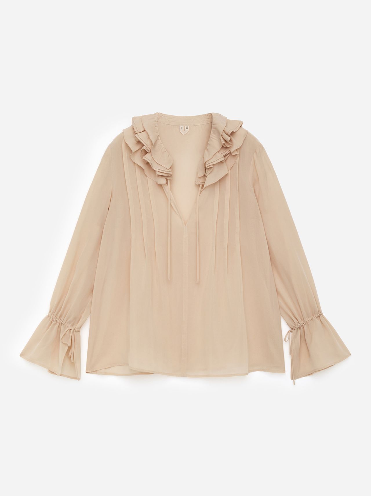 A beige, long-sleeve blouse with ruffled collar and cuffs, featuring pleated details and a v-neck with ties, against a white background.