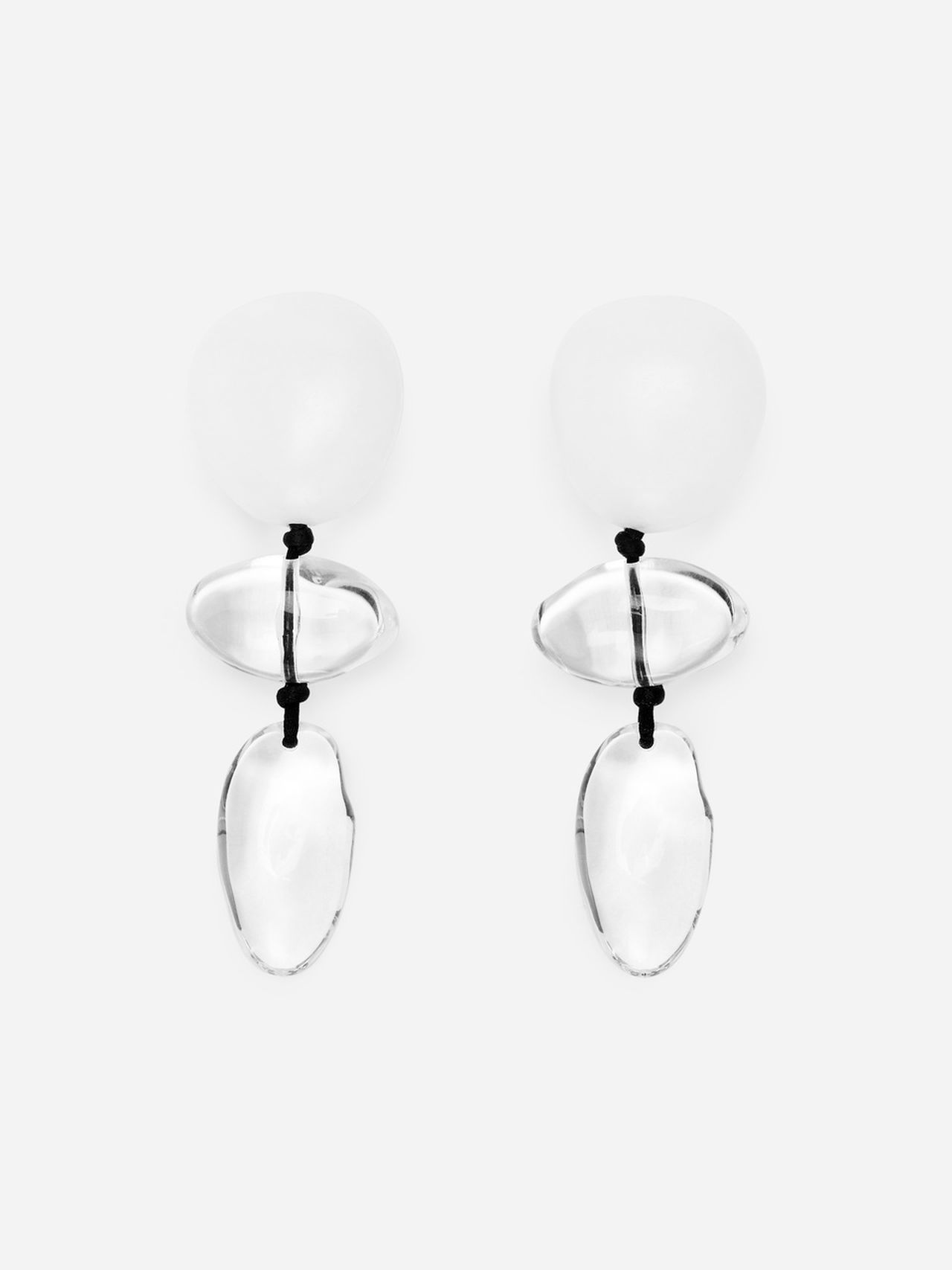 Pair of drop earrings with translucent, rounded shapes connected by black threads, set against a plain white background.