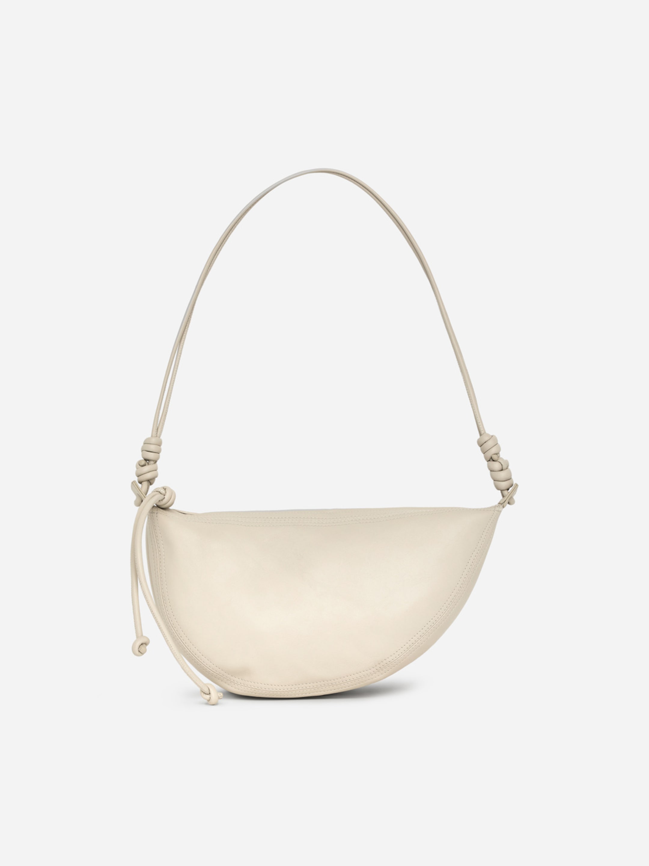 Cream-colored crescent-shaped handbag with twisted strap details, shown against a plain white background.