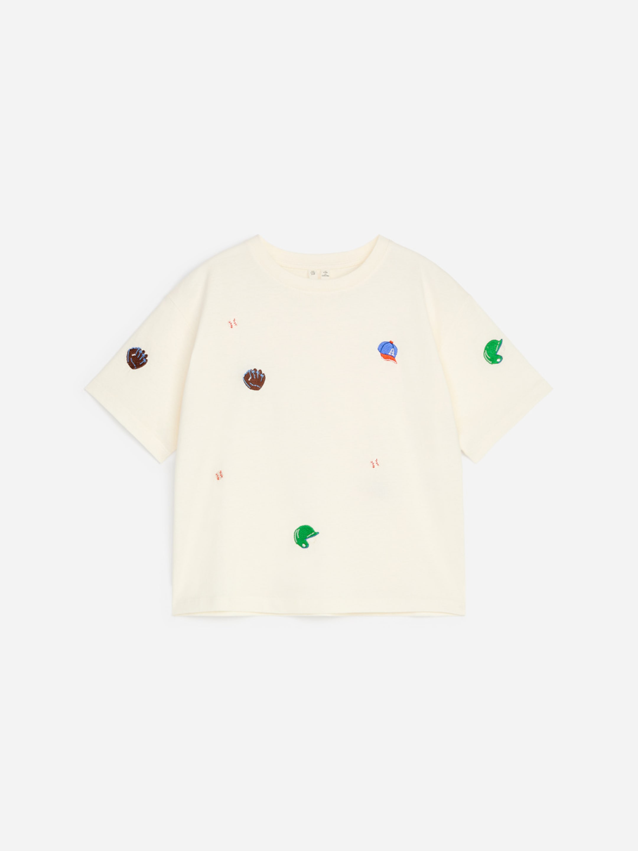 Cream-colored T-shirt with embroidered baseball motifs, including gloves, caps, and balls, scattered across the fabric.