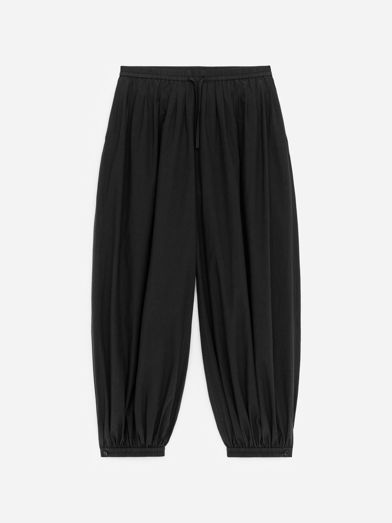 Black wide-leg pants with gathered elastic waist and cuffs, featuring a drawstring detail, on a white background.