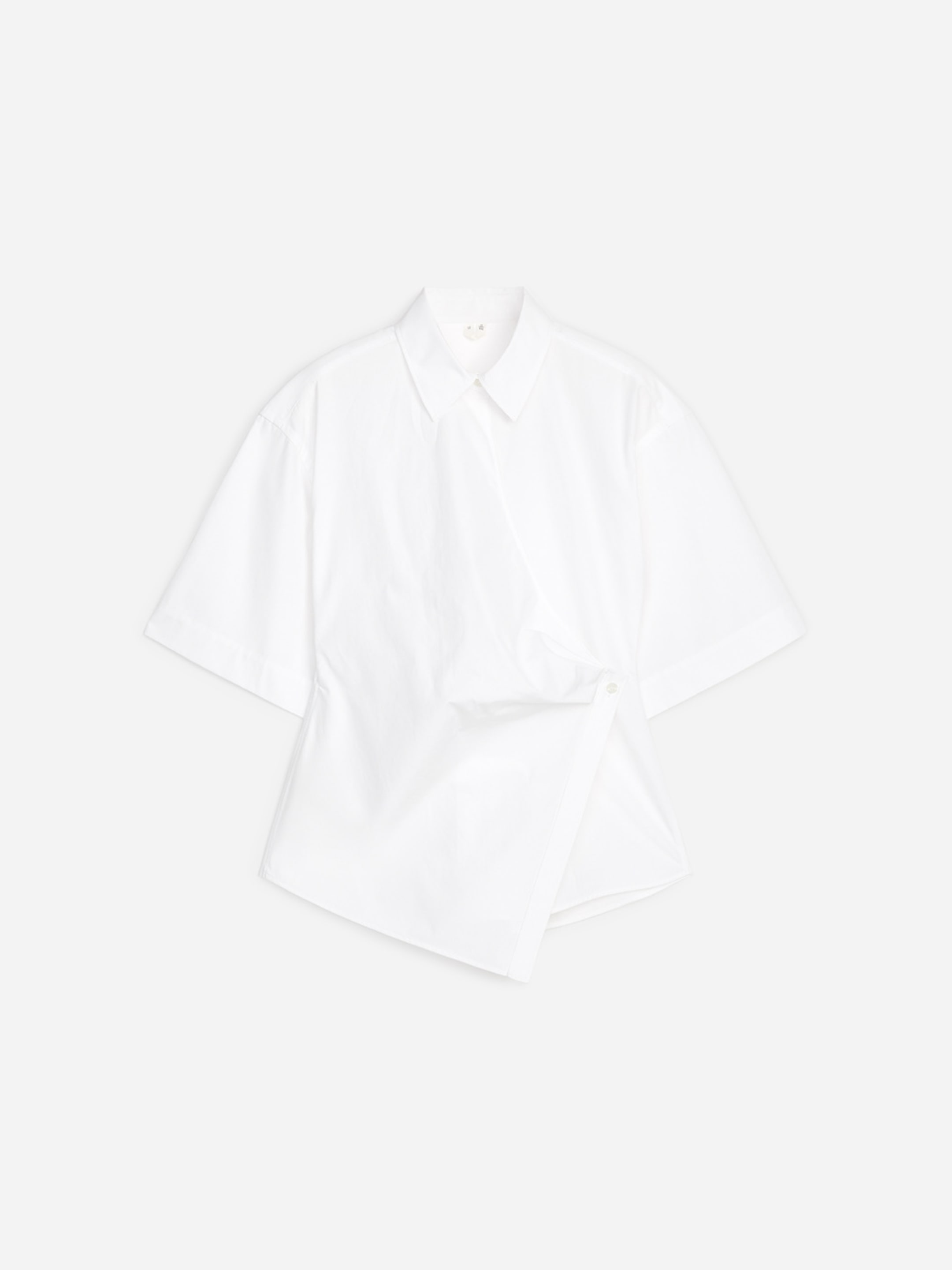 A white short-sleeve shirt with a classic collar, featuring a diagonal button-up design, displayed on a plain background.