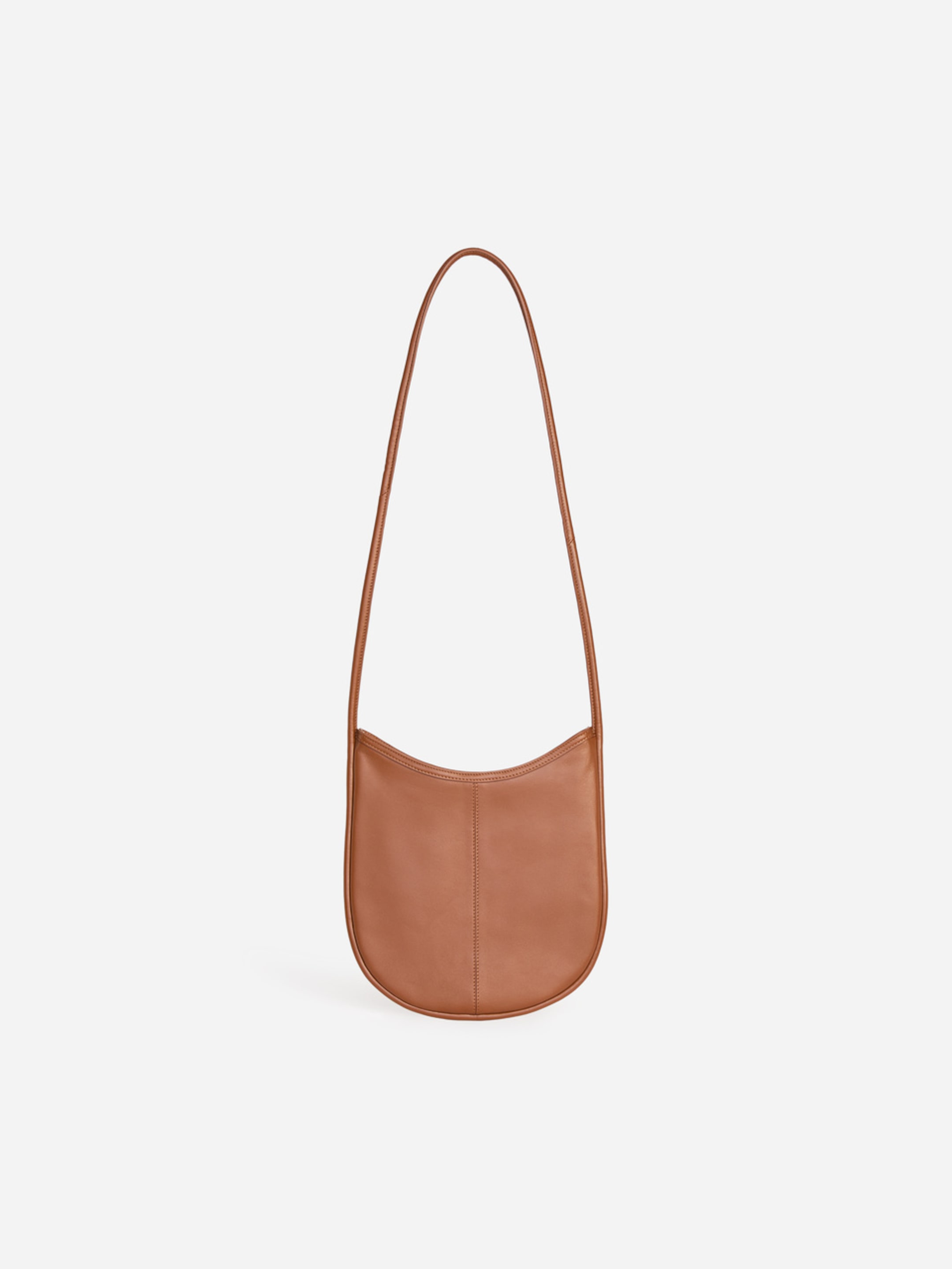 Brown leather shoulder bag with a curved shape and a single, long strap, set against a white background.