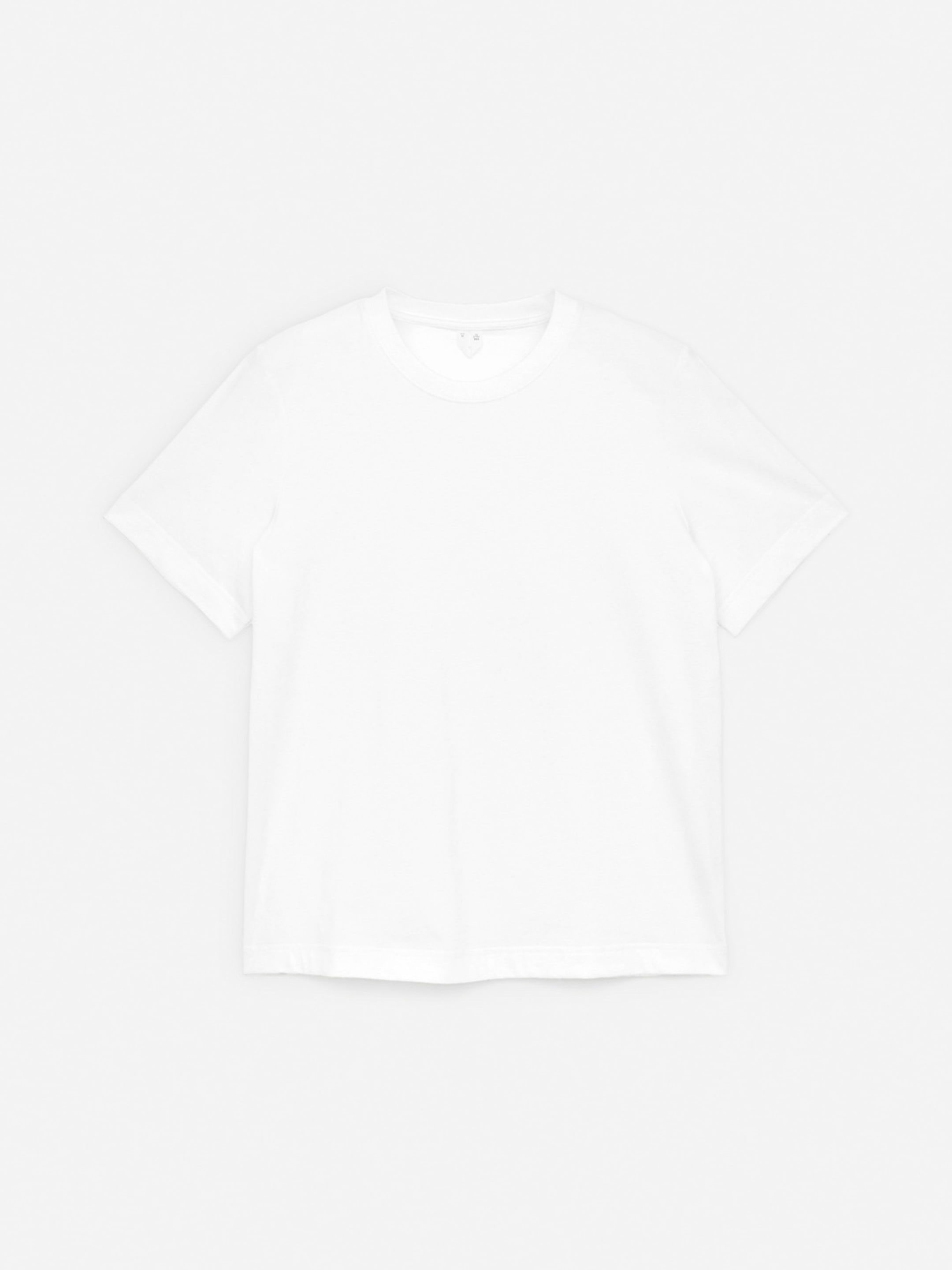 A plain white short-sleeve T-shirt is neatly laid flat on a light surface, displaying a simple and classic design.