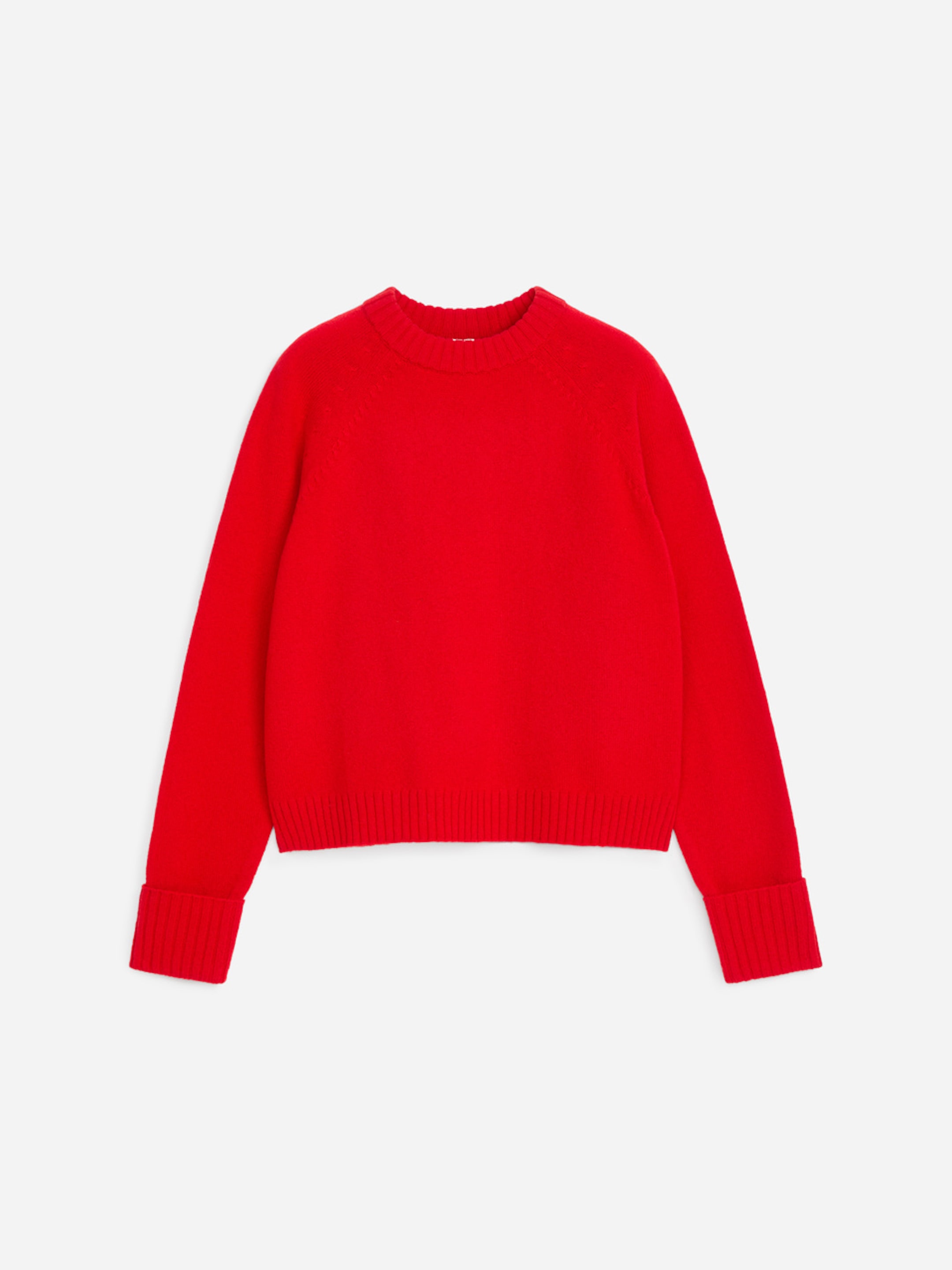 A bright red sweater with ribbed cuffs, hem, and crew neckline, laid flat on a light gray background.