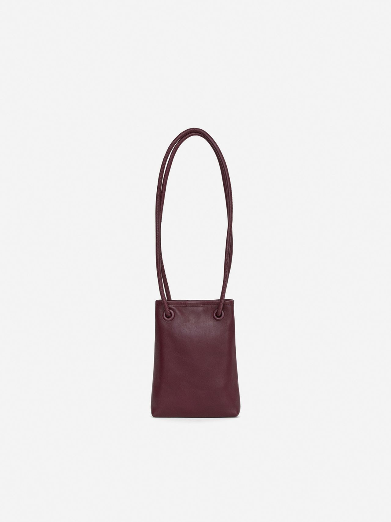 A small, dark brown leather handbag with a long, thin strap against a plain white background.