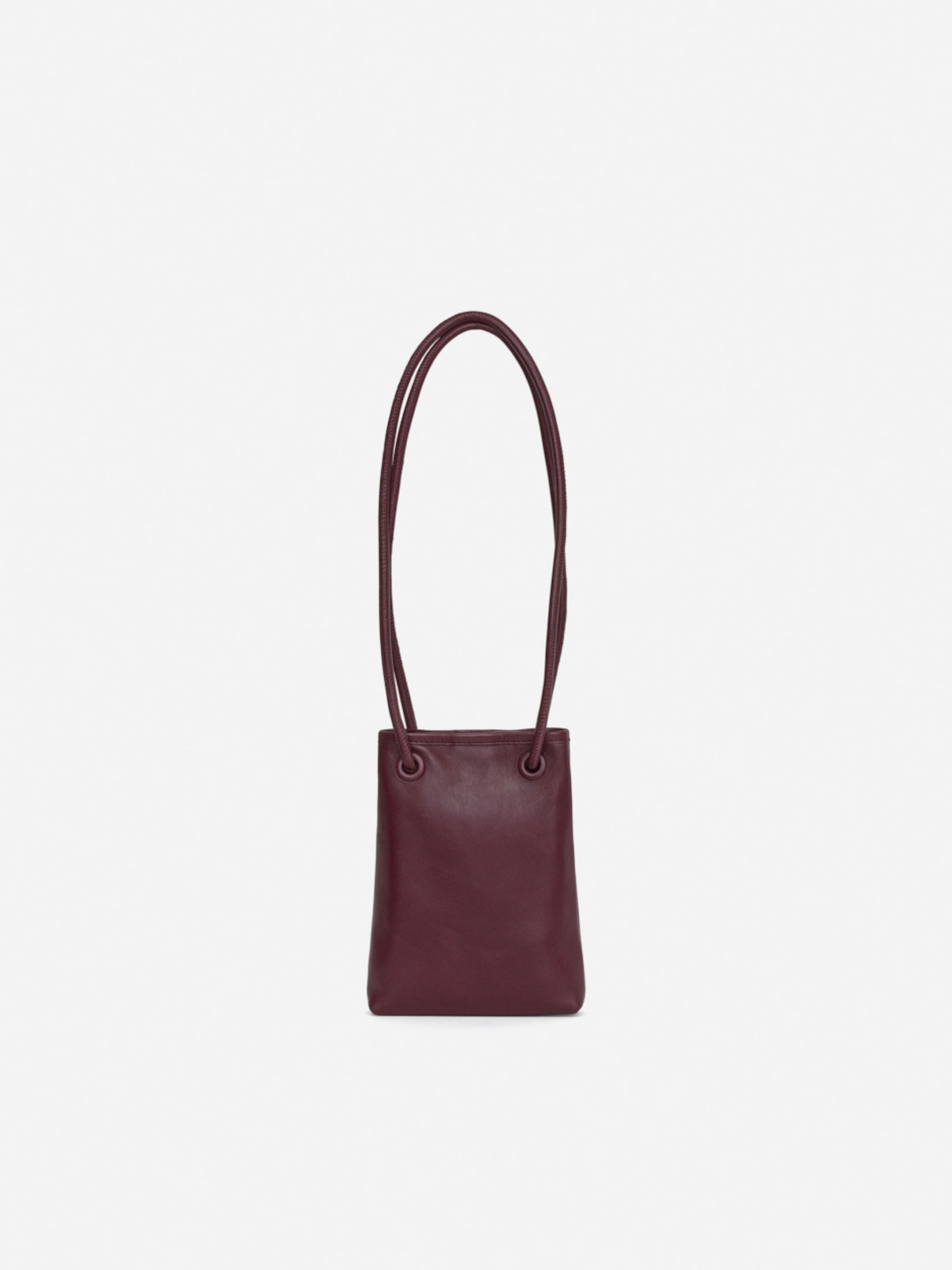 A small, dark brown leather handbag with a long, thin strap against a plain white background.