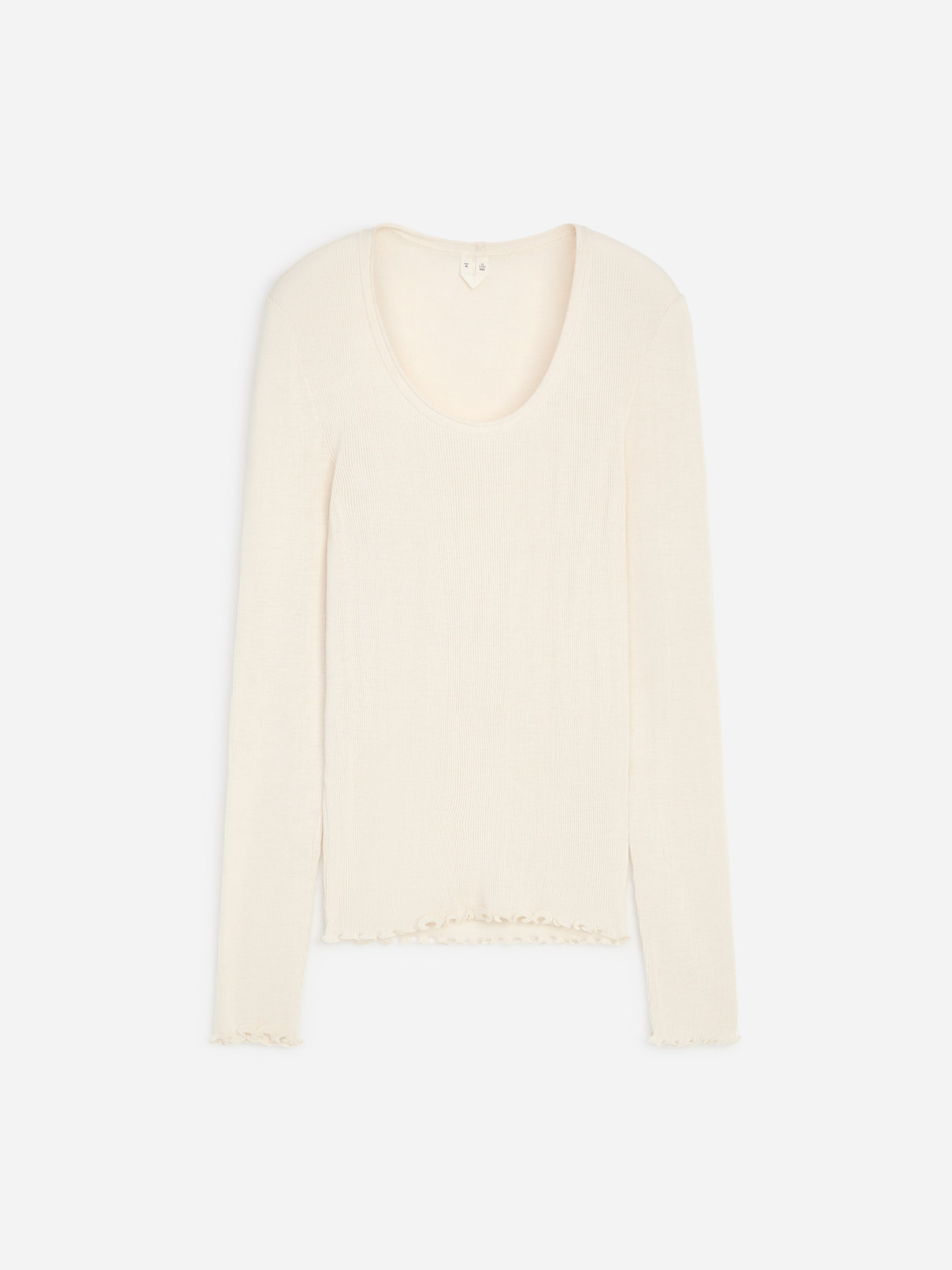 Cream-colored long-sleeve top with a scoop neckline and ruffled hem and cuffs, laid flat on a white background.