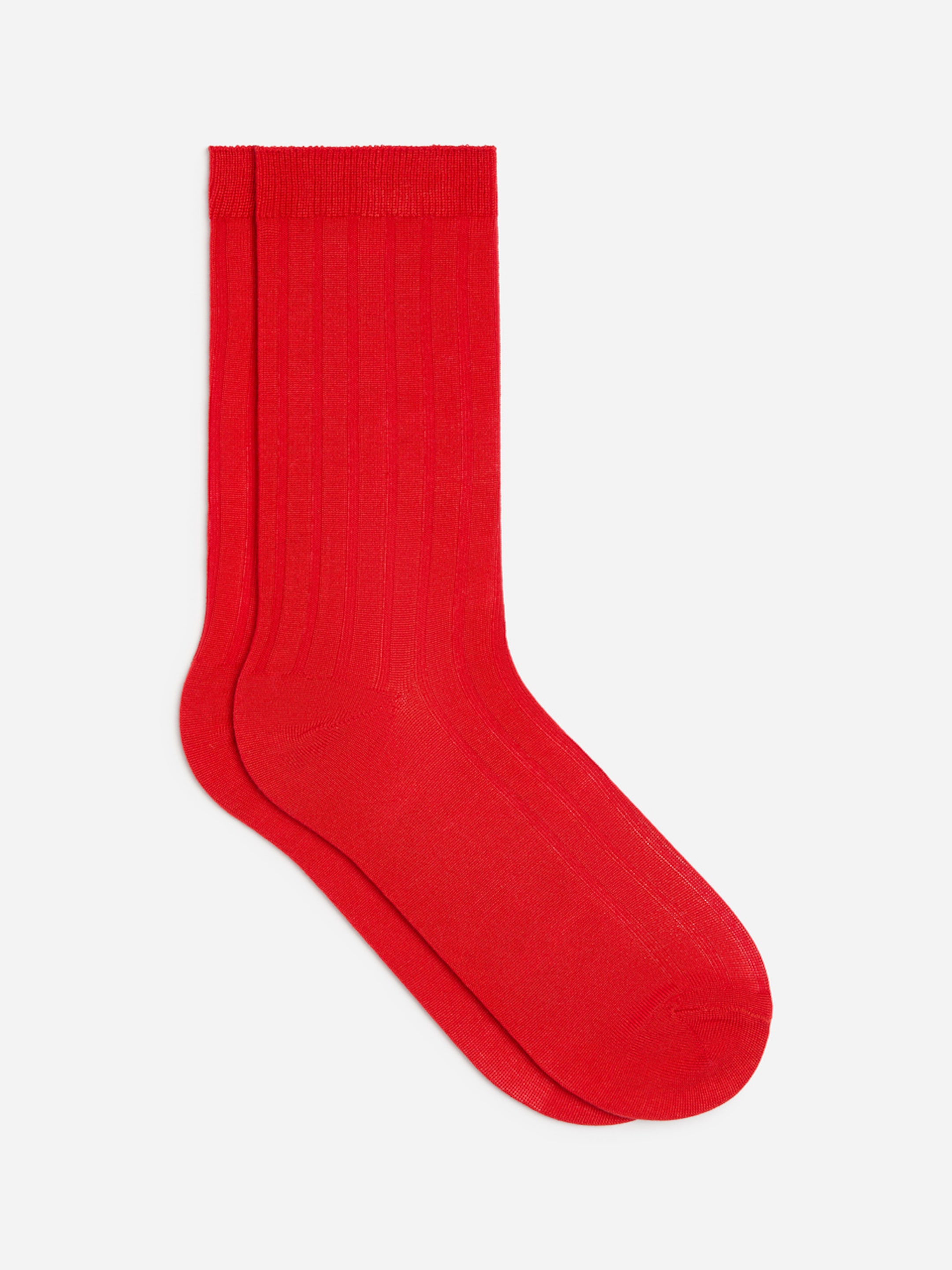A pair of bright red socks with ribbed texture, neatly stacked on a white background.