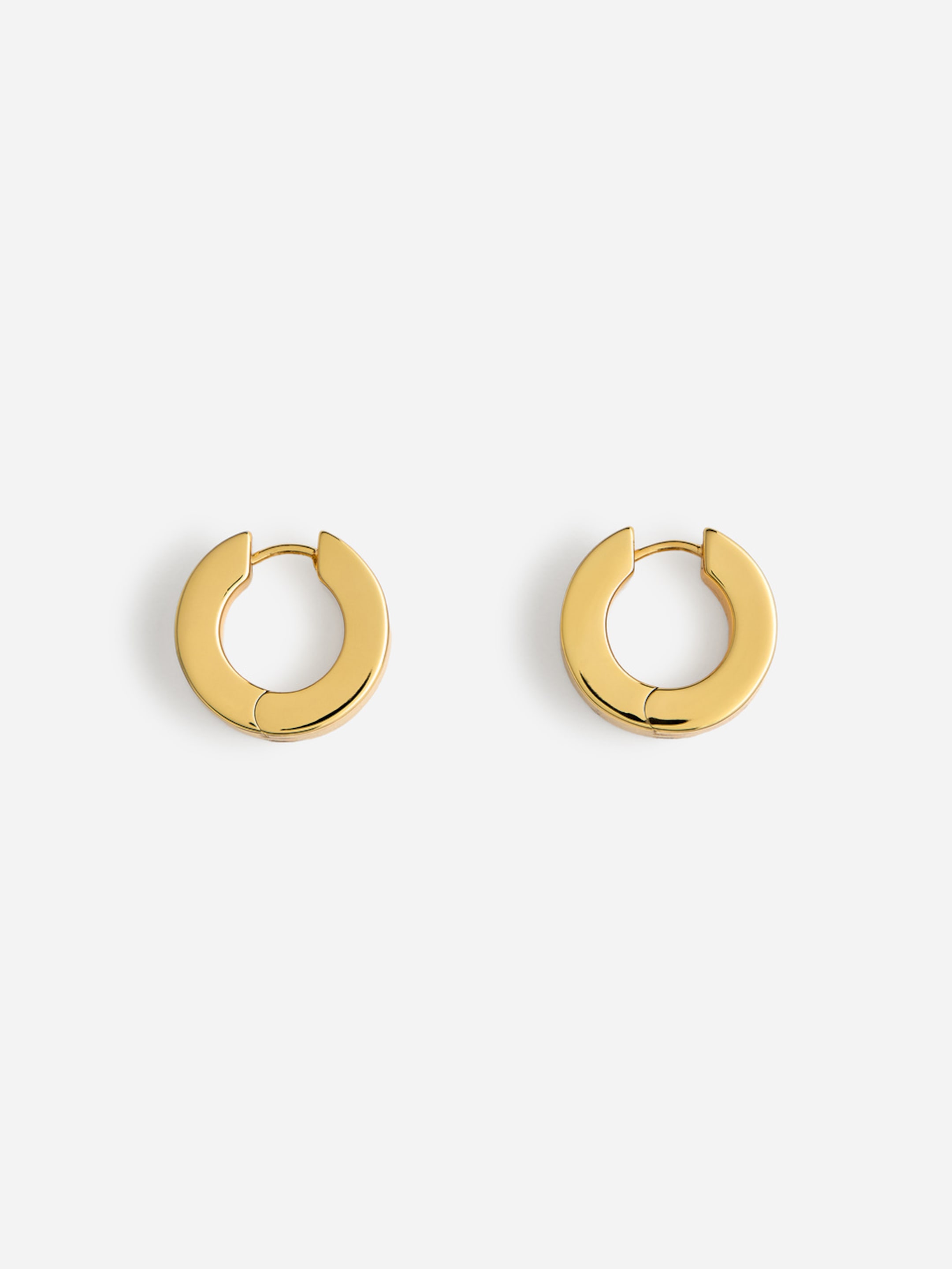 Two gold hoop earrings on a white background.