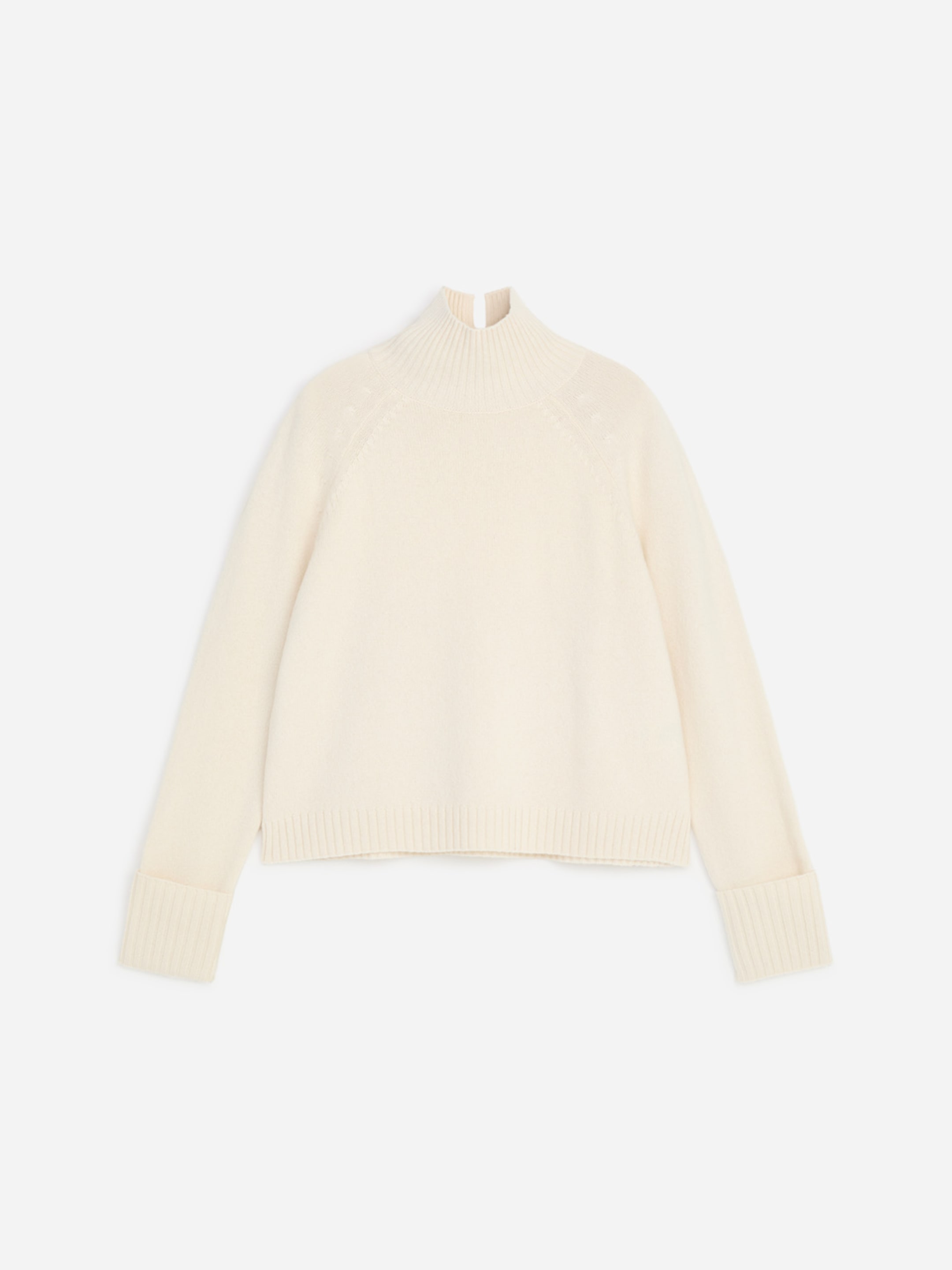 Ivory turtleneck sweater with ribbed cuffs and hem, laid flat on a white background.