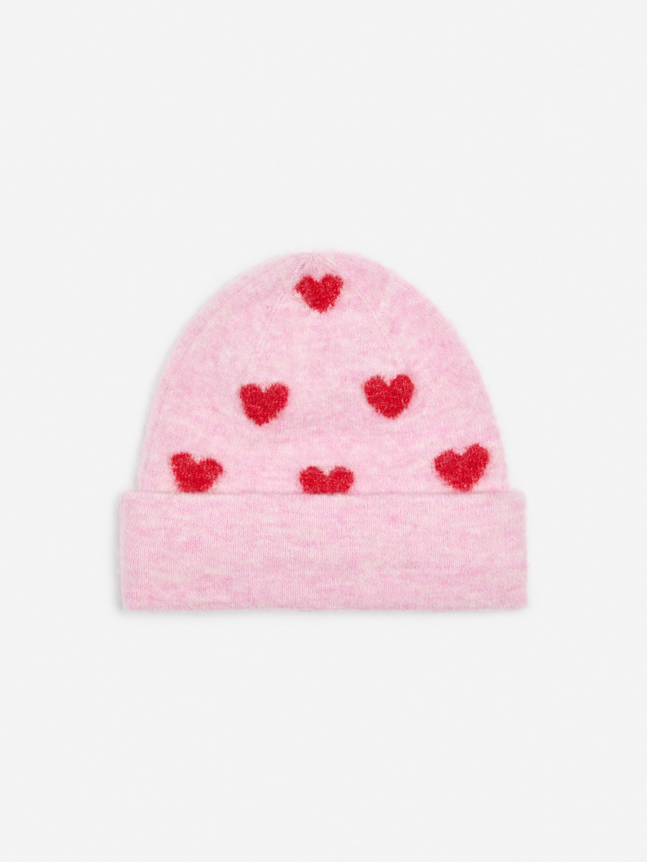 Pink knit hat with red heart patterns scattered across the surface, against a white background.