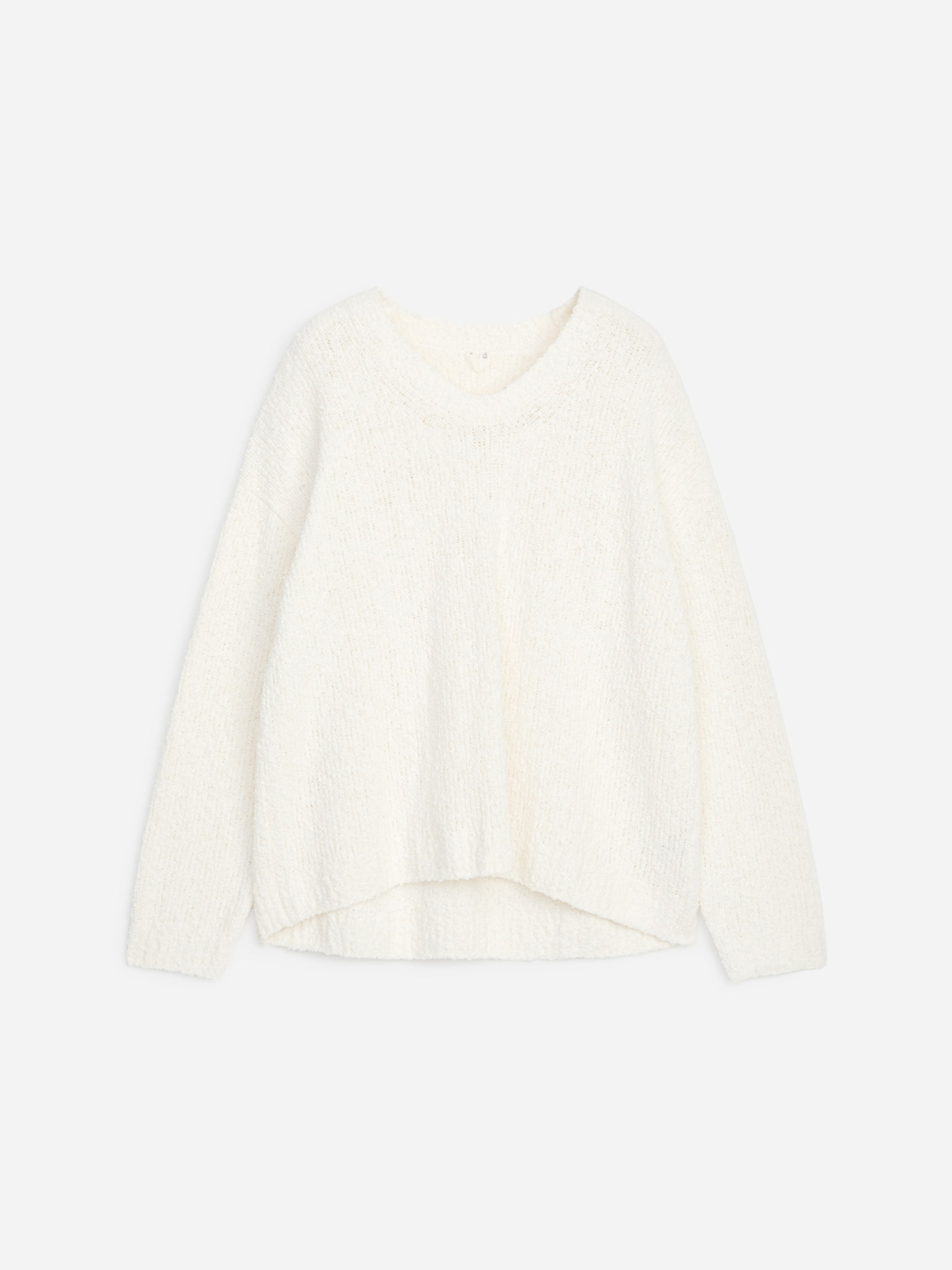 White knitted sweater with a slightly curved hem and long sleeves, displayed on a light grey background.